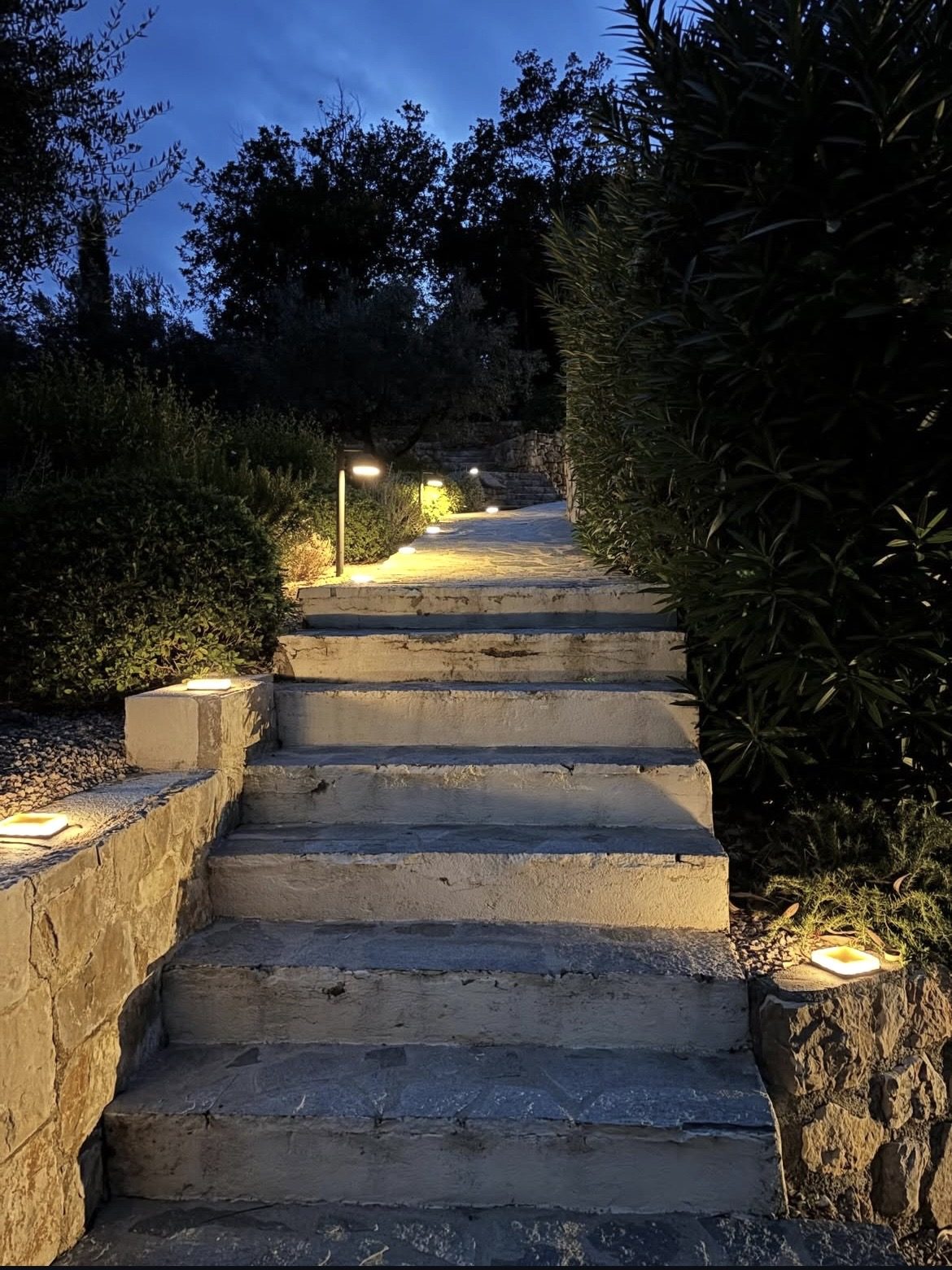 Escalier extérieur en pierre éclairé par des spots encastrés le soir