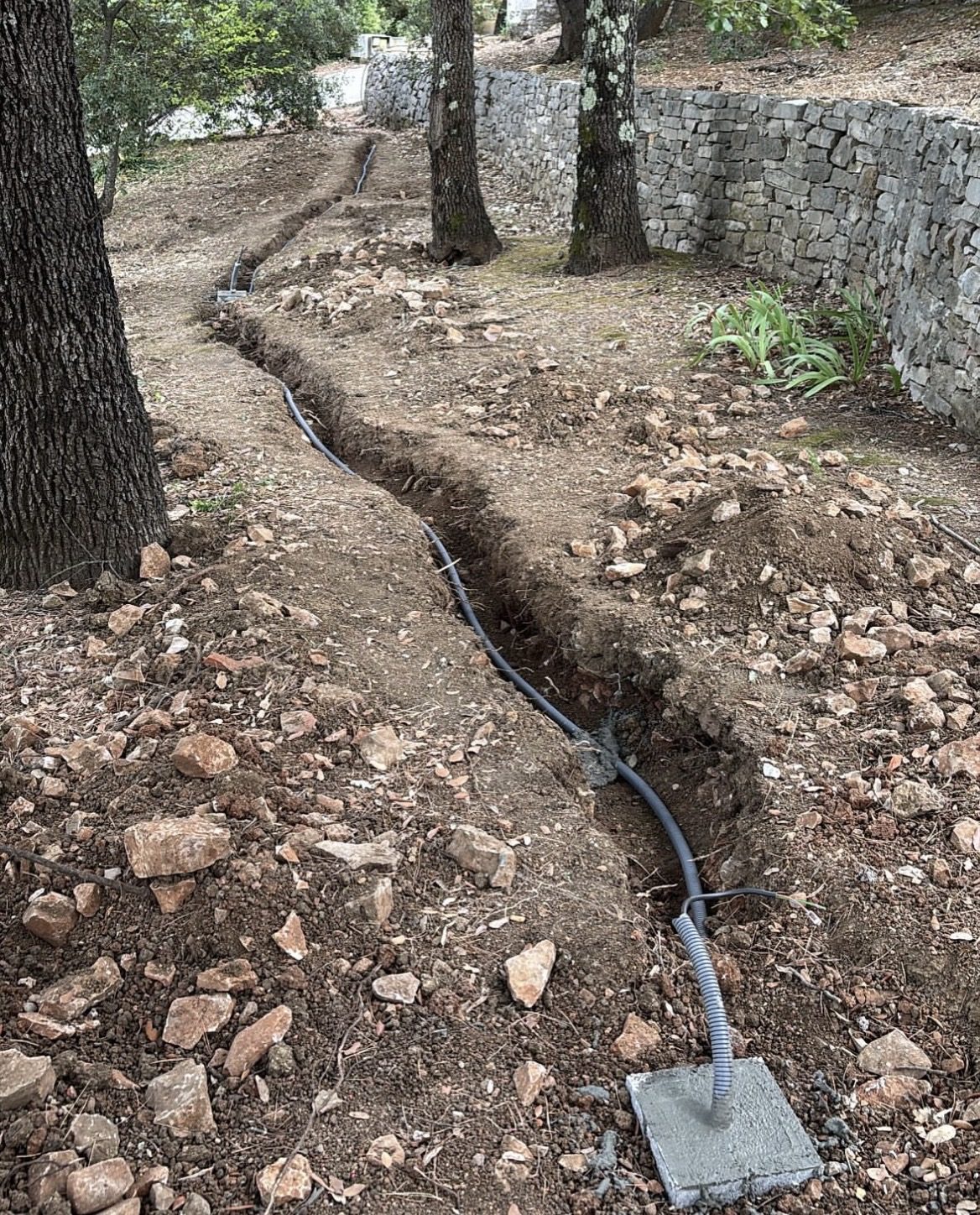 Tranchée et câblage enterré pour éclairage de jardin, en cours de chantier